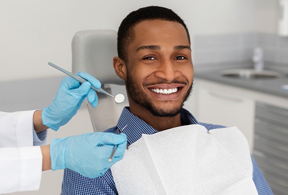 Man smiling while sitting in dentist's treatment chair