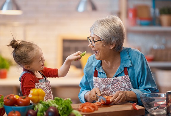 a grandparent cooking food with her grandchild