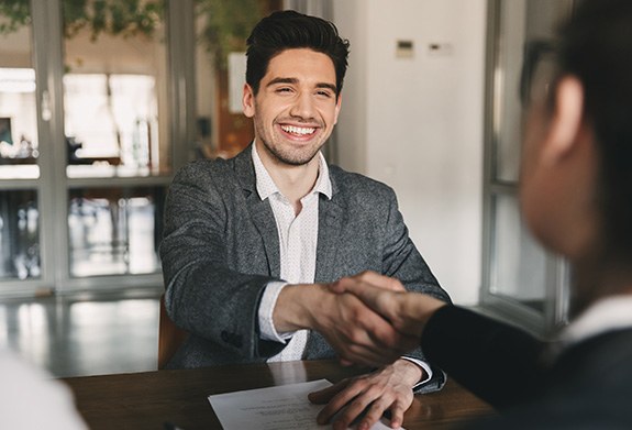 a man shaking hands with a person interviewing him for a job